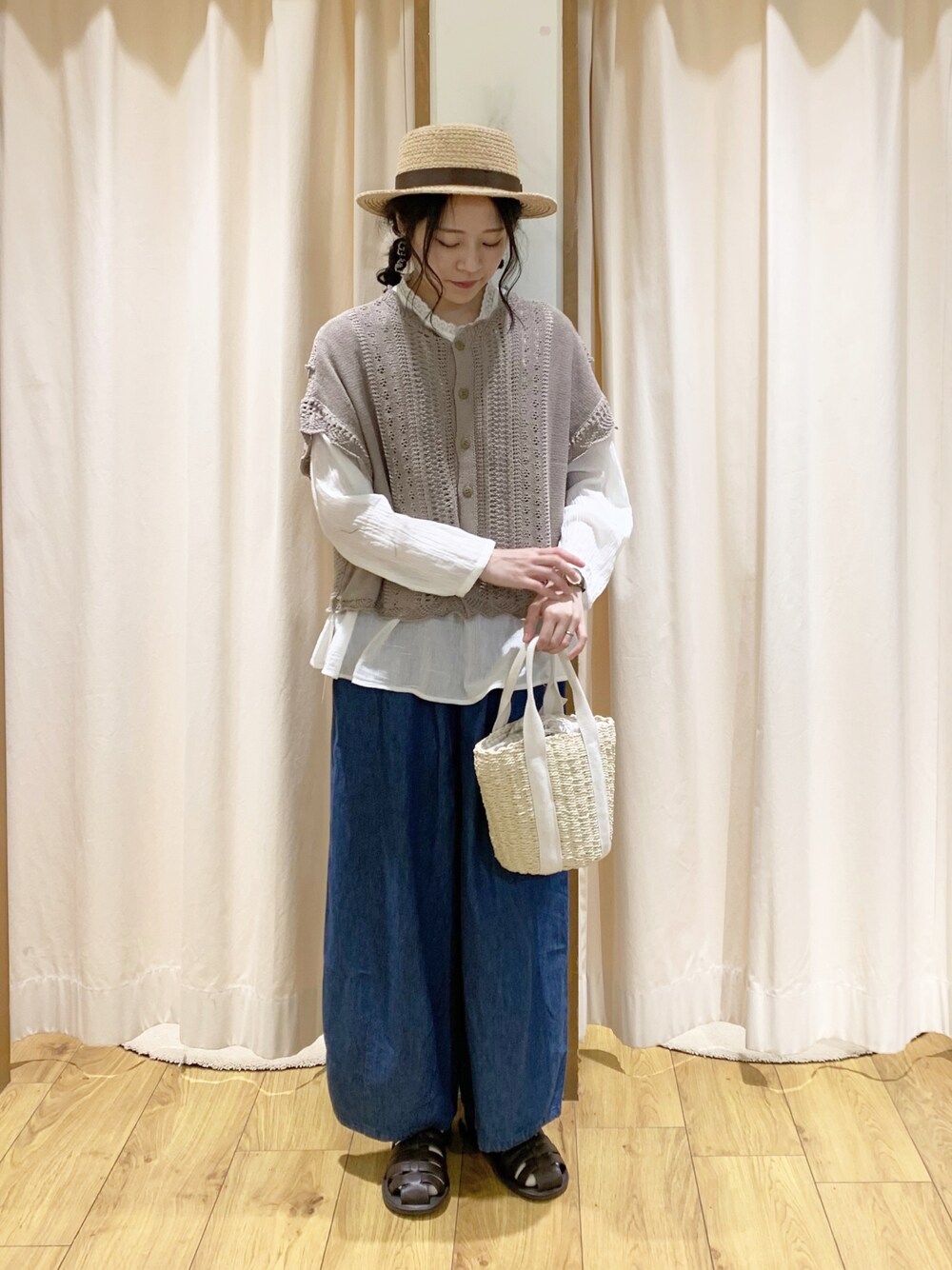 ブラウン系のベスト、ホワイト系のシャツ/ブラウス、ブルー系のデニムパンツを着用したレディースの春コーディネートの1枚目の写真