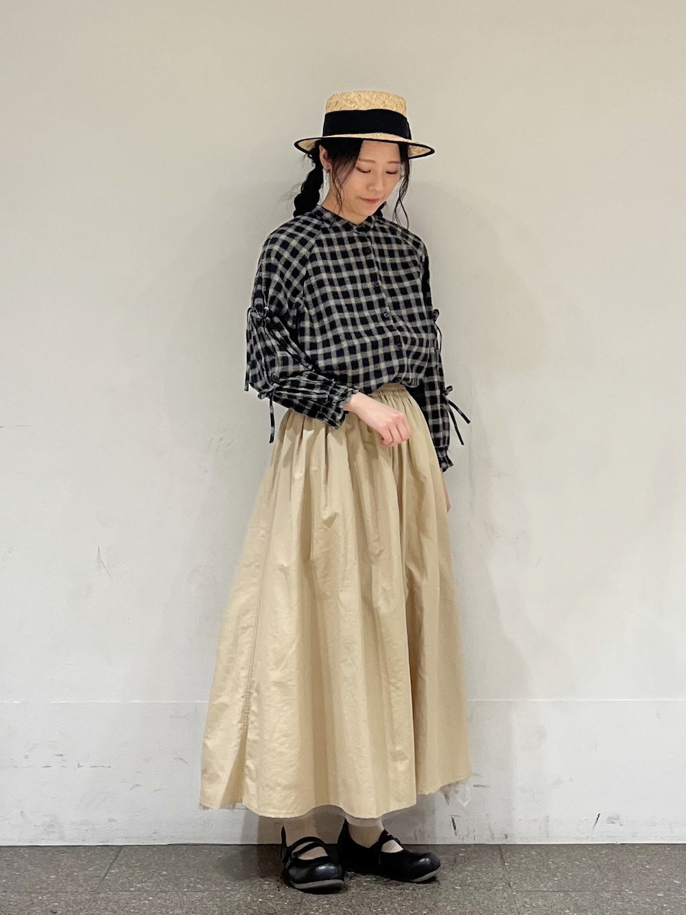 ブラック系のシャツ/ブラウス、ベージュ系のスカート、ブラック系のハットを着用したレディースの冬コーディネートの1枚目の写真