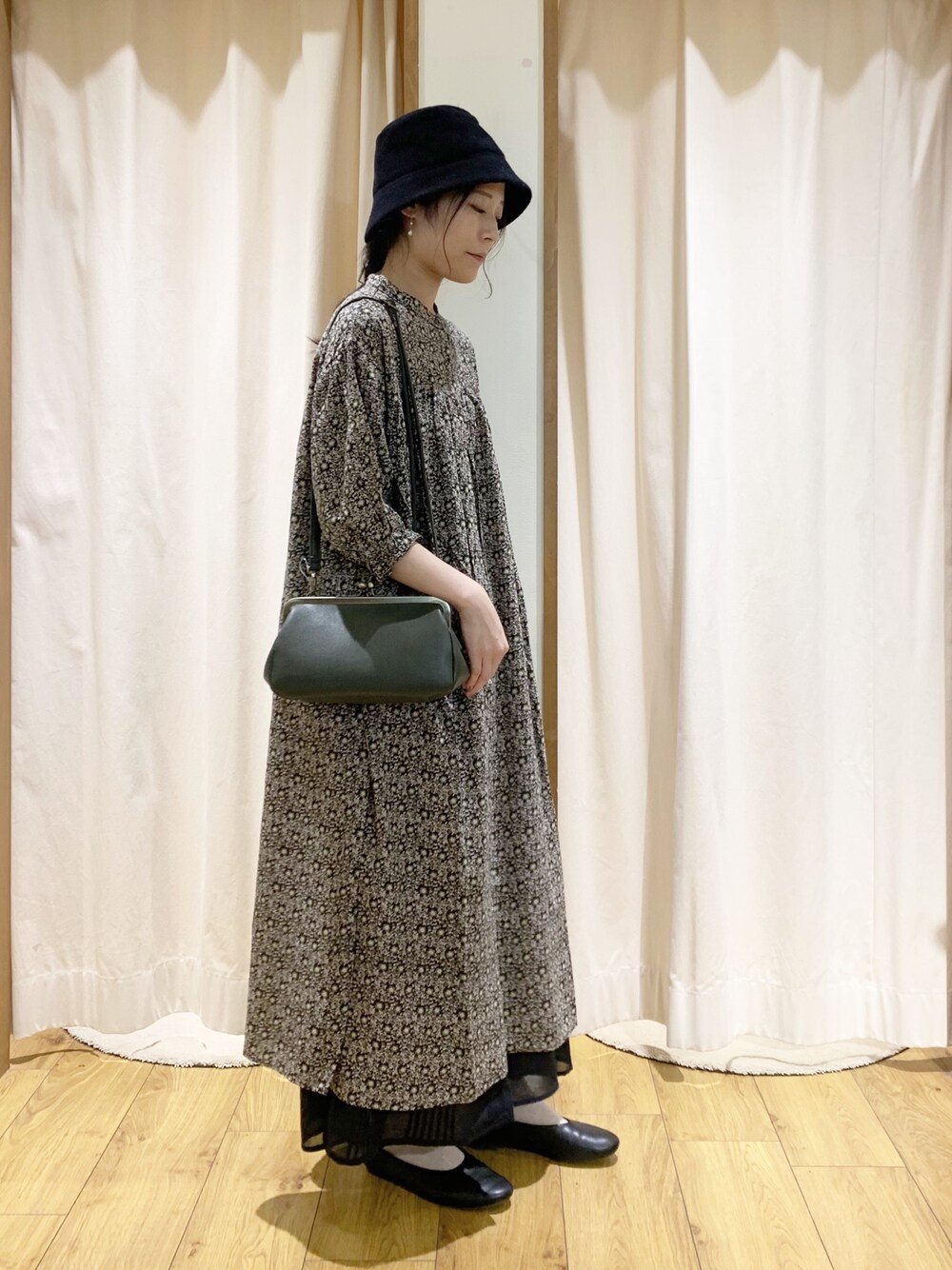 グレー系のワンピース、ホワイト系のTシャツ/カットソー、ブラック系のスカートを着用したレディースの夏コーディネートの1枚目の写真