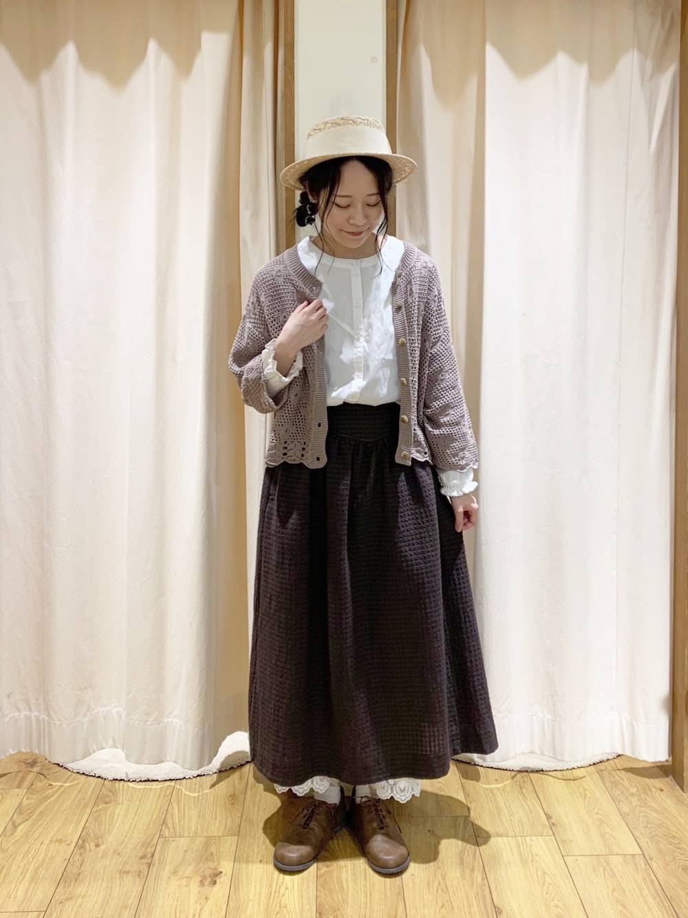 ホワイト系のシャツ/ブラウス、ブラウン系のカーディガン/ボレロ、グレー系のスカートを着用したレディースの春コーディネートの1枚目の写真