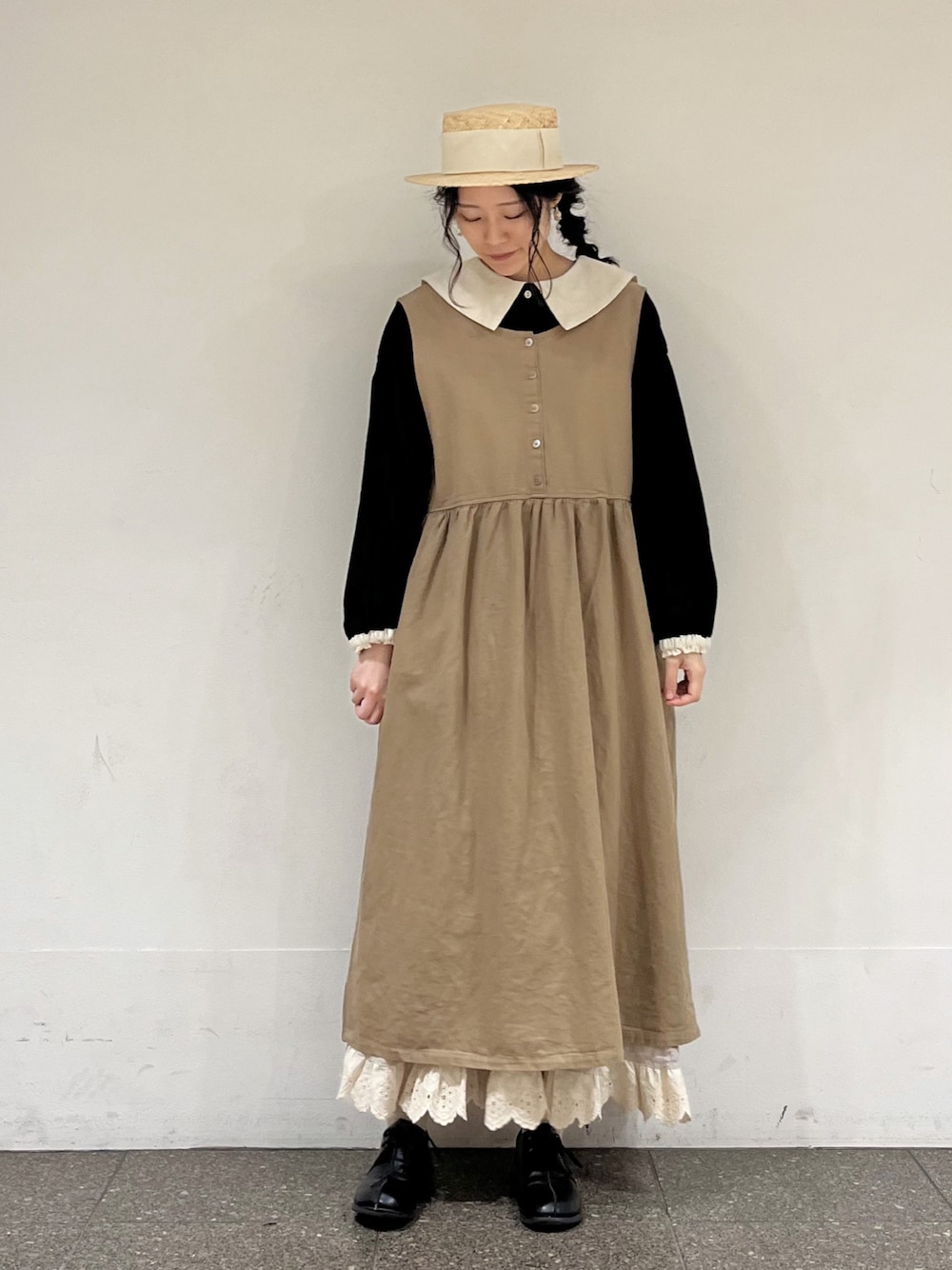 ブラック系のシャツ/ブラウス、ベージュ系のスカート、ベージュ系のワンピースを着用したレディースの冬コーディネートの1枚目の写真