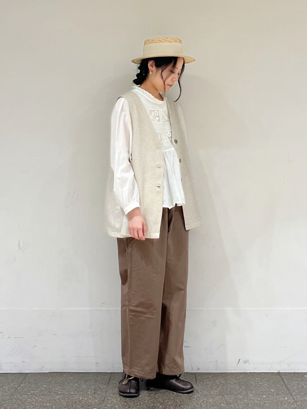 ベージュ系のベスト、ブラウン系のその他パンツ、ホワイト系のシャツ/ブラウスを着用したレディースの冬コーディネートの1枚目の写真
