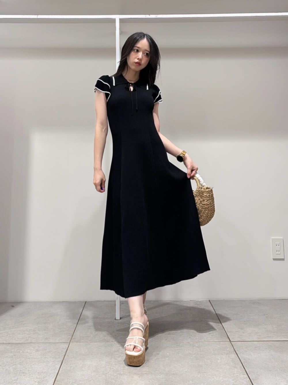 ベージュ系のハンドバッグ、その他のサンダル、ブルー系のワンピースを着用したレディースの夏コーディネートの1枚目の写真