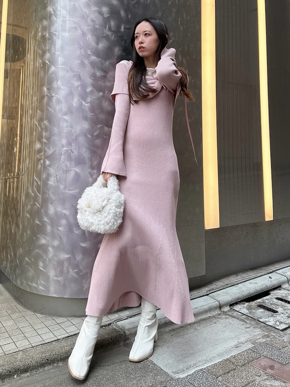 ピンク系のワンピース、ホワイト系のハンドバッグ、ホワイト系のブーツを着用したレディースの冬コーディネートの1枚目の写真