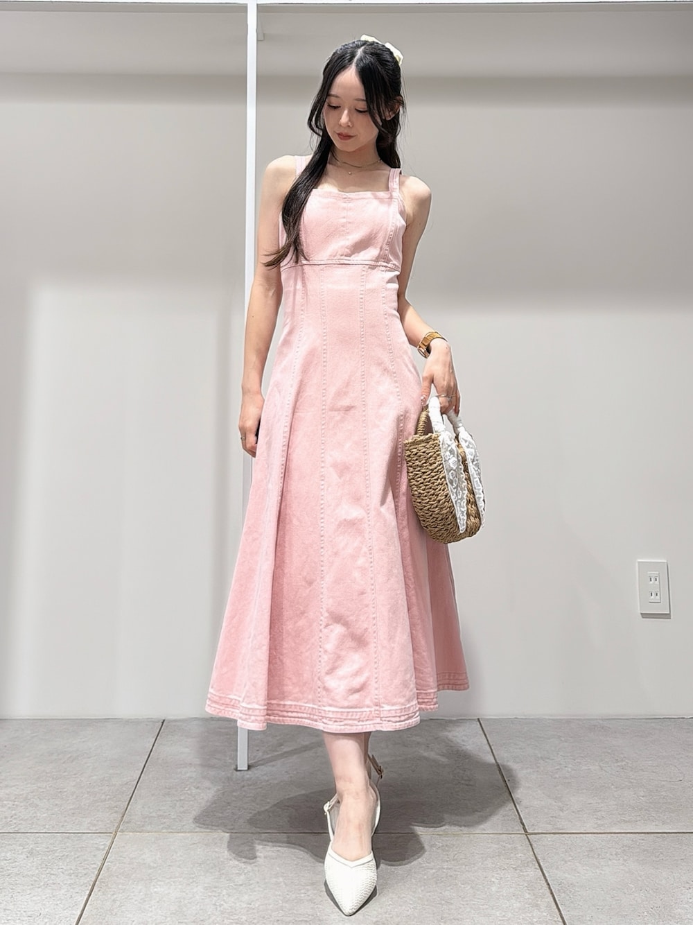 ピンク系のワンピース、ホワイト系のパンプス、ベージュ系のハンドバッグを着用したレディースの春コーディネートの1枚目の写真