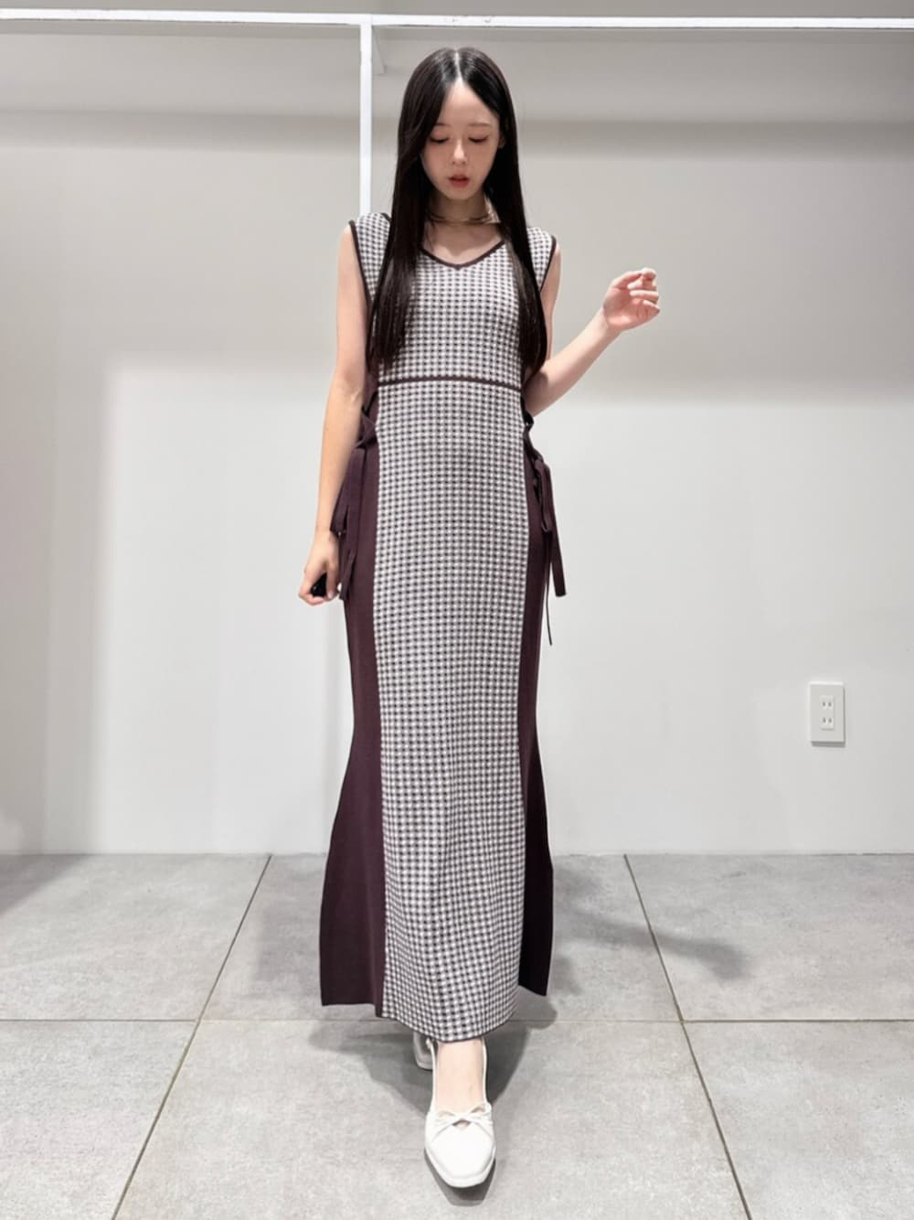 ブラウン系のワンピース、ホワイト系のパンプスを着用したレディースの夏コーディネートの1枚目の写真