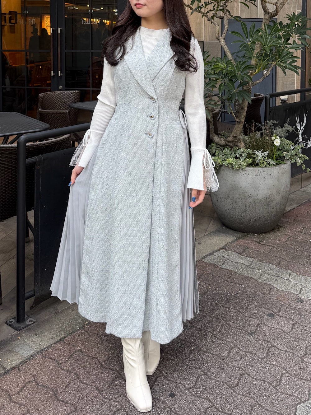 ホワイト系のブーツ、グレー系のワンピースを着用したレディースの春コーディネートの1枚目の写真
