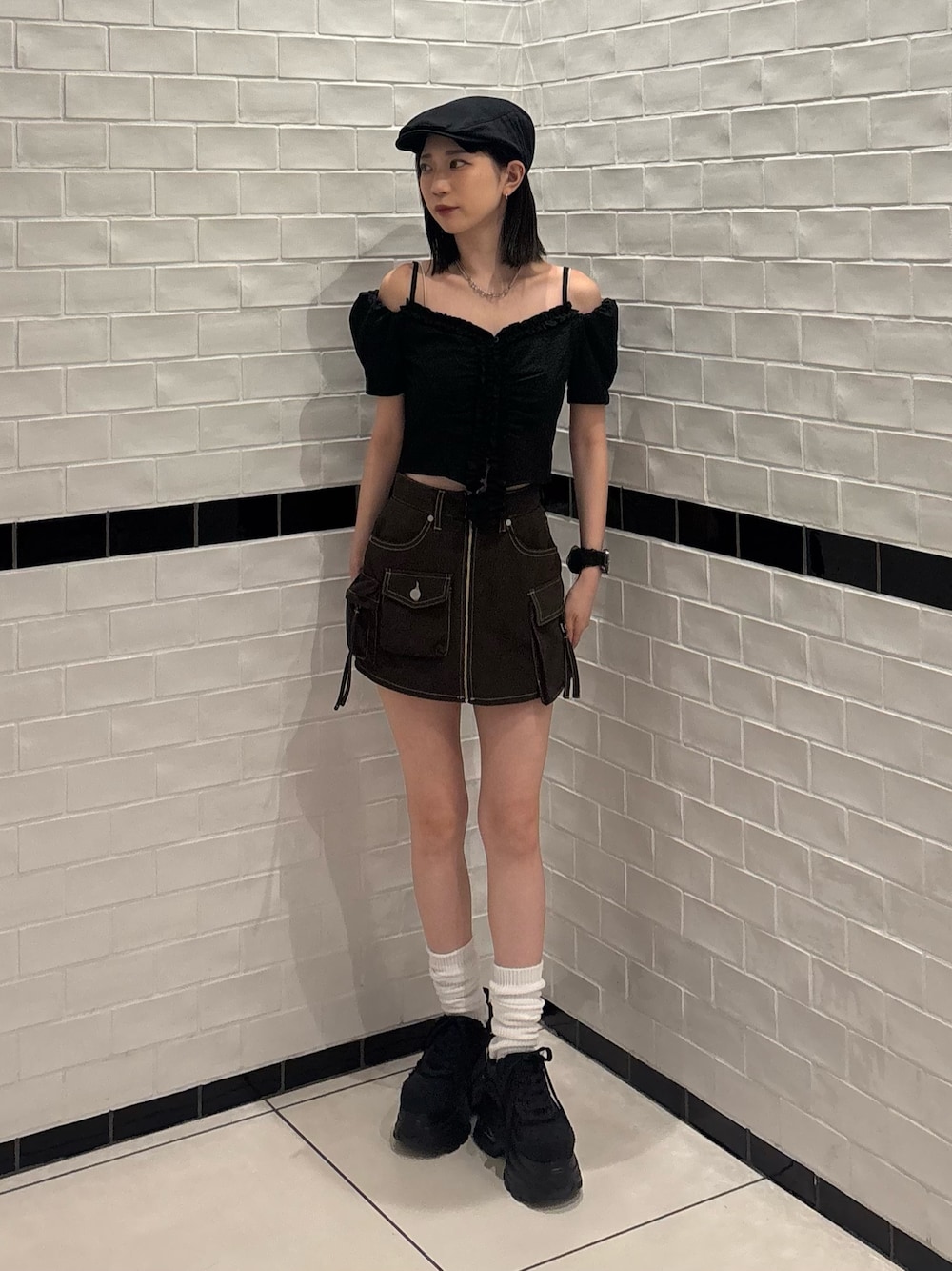 ブラック系のTシャツ/カットソー、ブラウン系のスカート、ブラック系のスニーカーを着用したレディースの夏コーディネートの1枚目の写真