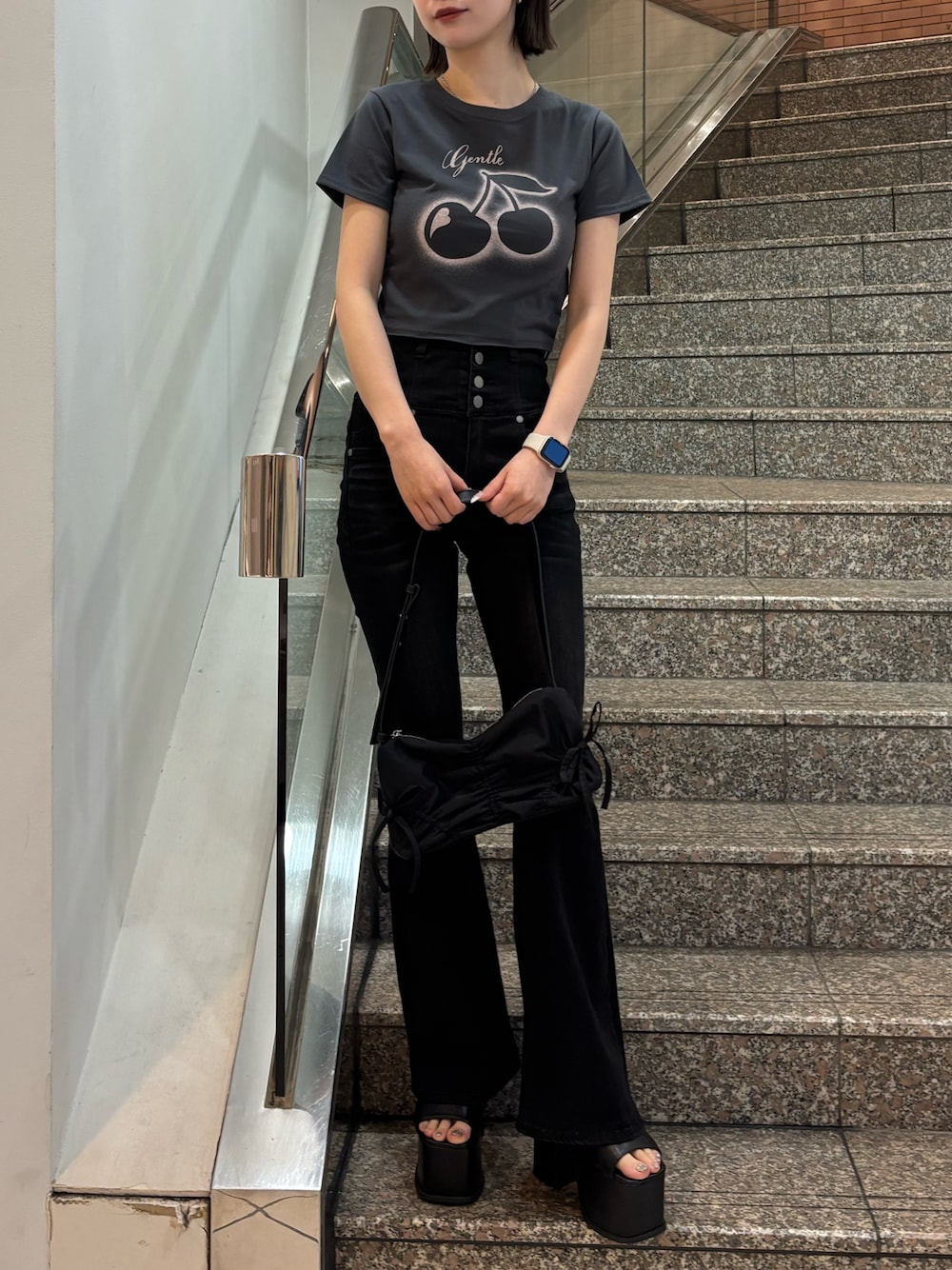 グレー系のTシャツ/カットソー、ブラック系のデニムパンツ、ブラック系のハンドバッグを着用したレディースの春コーディネートの1枚目の写真