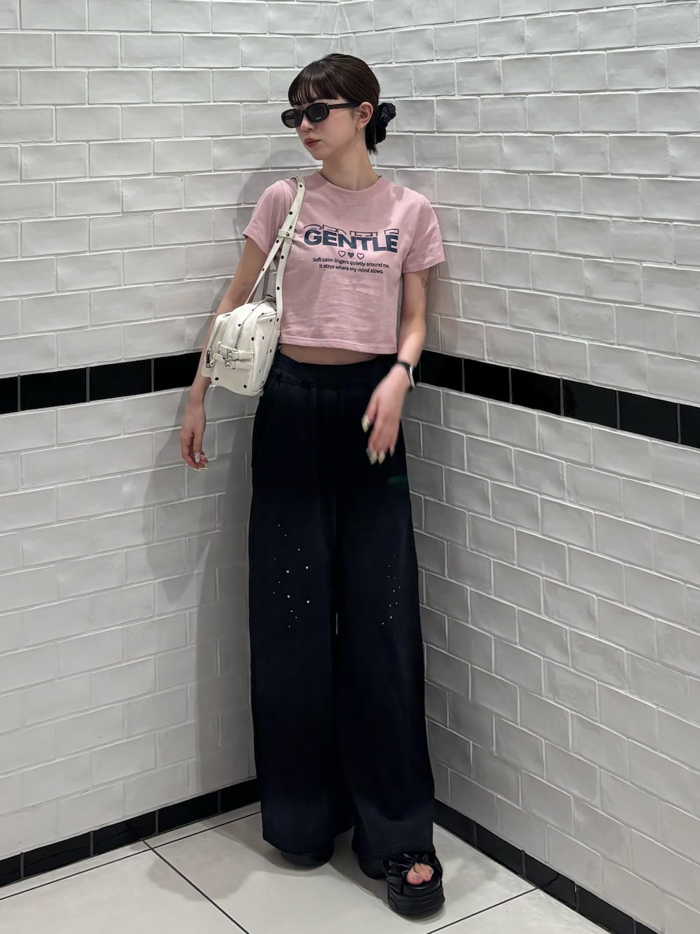 ピンク系のTシャツ/カットソー、ブラック系のスウェットパンツ、ホワイト系のショルダーバッグを着用したレディースの夏コーディネートの1枚目の写真