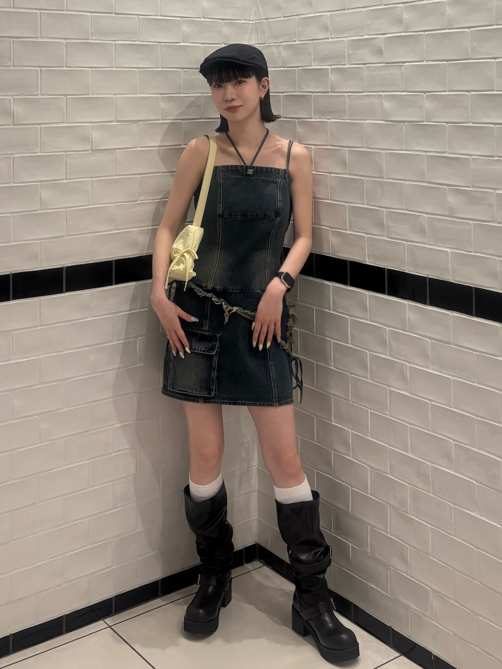 ブルー系のワンピース、ブラック系のハンドバッグ、ブラック系のブーツを着用したレディースの春コーディネートの1枚目の写真