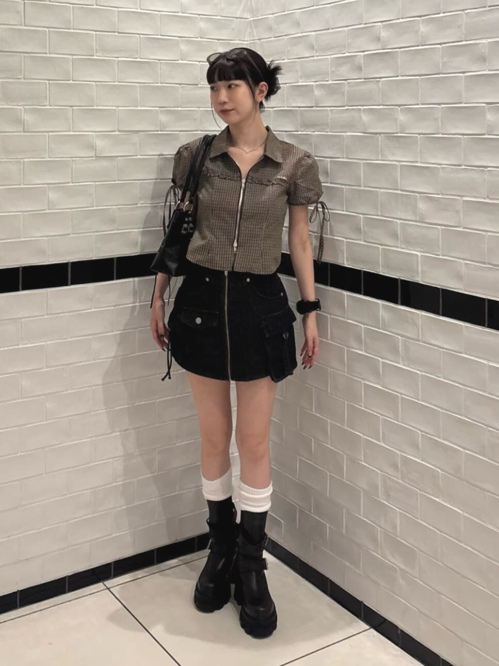 ブラック系のスカート、ブラック系のショルダーバッグ、ブラウン系のTシャツ/カットソーを着用したレディースの夏コーディネートの1枚目の写真