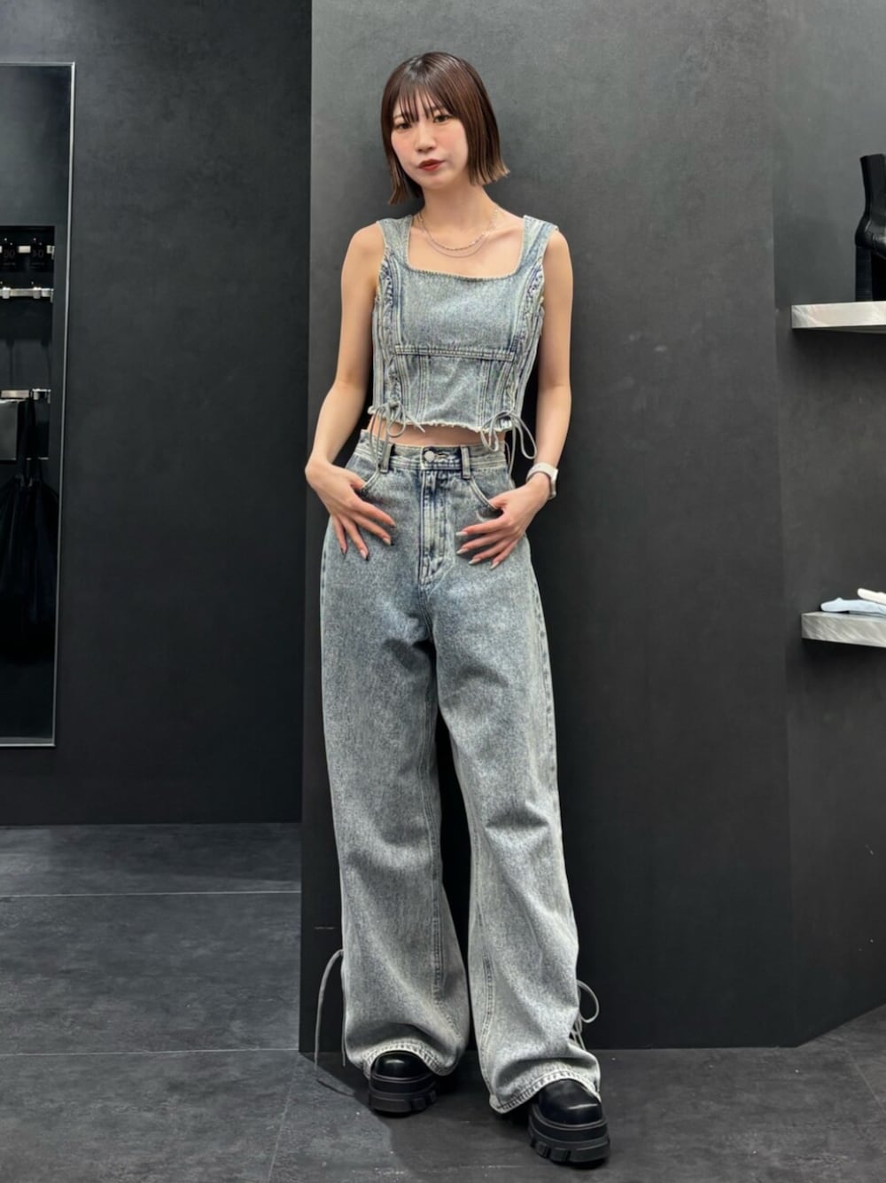 ブラック系のブーツ、ブルー系のタンクトップ、ブルー系のデニムパンツを着用したレディースの春コーディネートの1枚目の写真