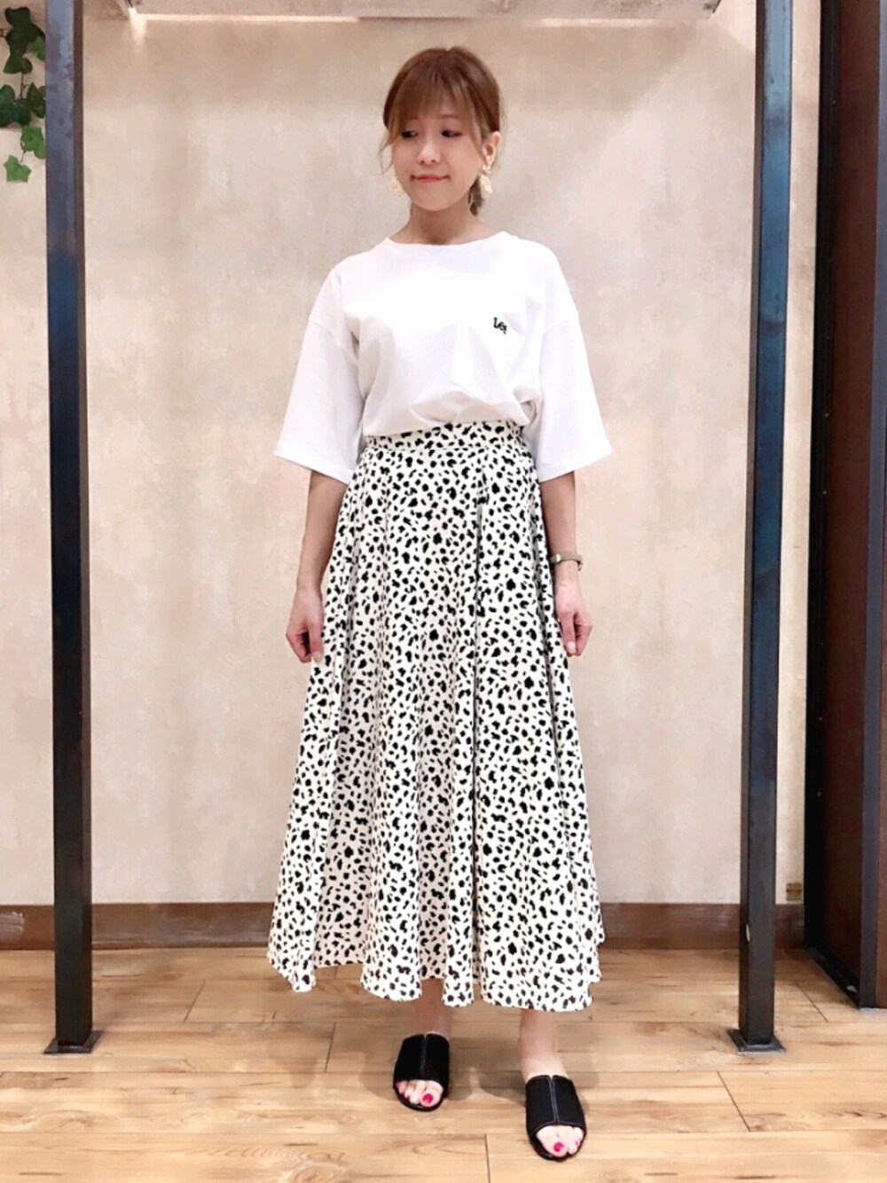 ブラック系のサンダル、ブラック系のスカート、ホワイト系のTシャツ/カットソーを着用したレディースの夏コーディネートの1枚目の写真