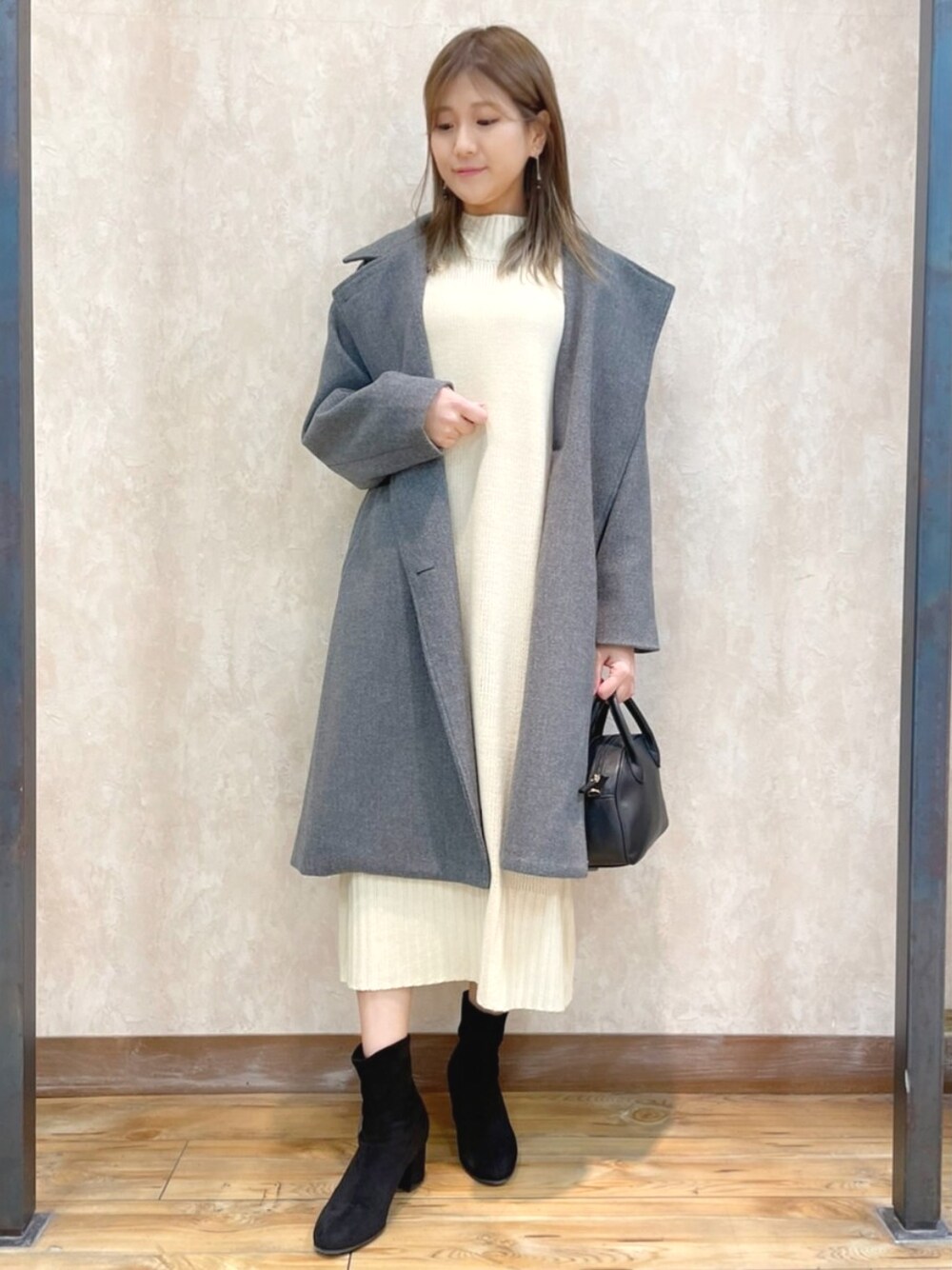 ホワイト系のワンピース、グレー系のダウンジャケット/コート、ブラック系のバッグを着用したレディースの冬コーディネートの1枚目の写真