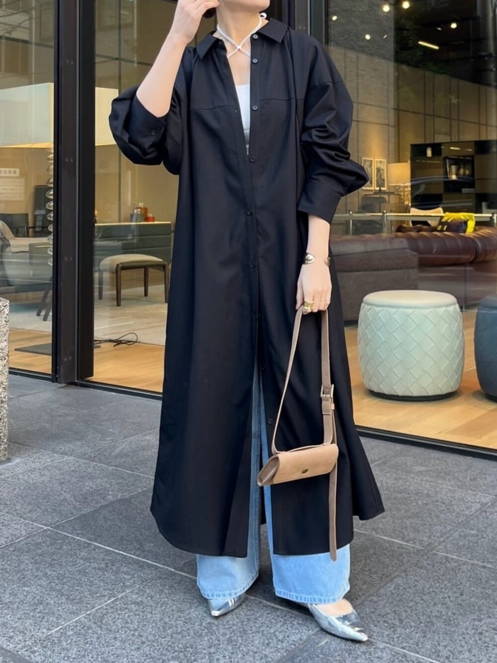 ブラック系のワンピース、ブルー系のデニムパンツ、ホワイト系のキャミソールを着用したレディースの冬コーディネートの1枚目の写真