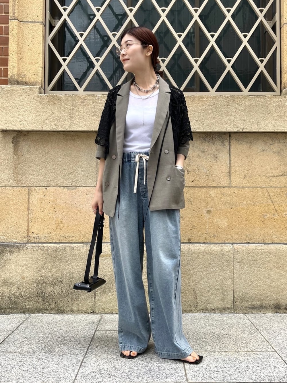 ベージュ系のテーラードジャケット、ブルー系のデニムパンツ、ホワイト系のTシャツ/カットソーを着用したレディースの夏コーディネートの1枚目の写真