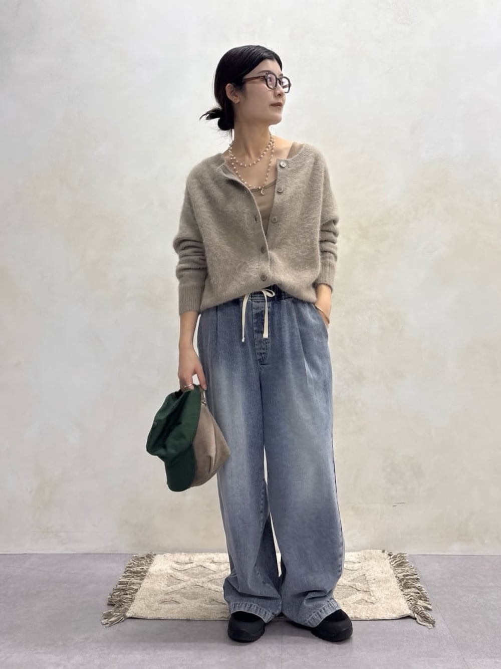 ブラウン系のカーディガン/ボレロ、ブルー系のデニムパンツ、ゴールド系のネックレスを着用したレディースの秋コーディネートの1枚目の写真