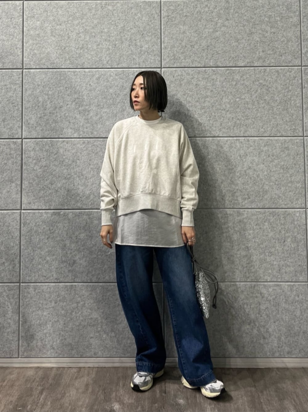 シルバー系のショルダーバッグ、ブルー系のデニムパンツ、ホワイト系のTシャツ/カットソーを着用したレディースの冬コーディネートの1枚目の写真