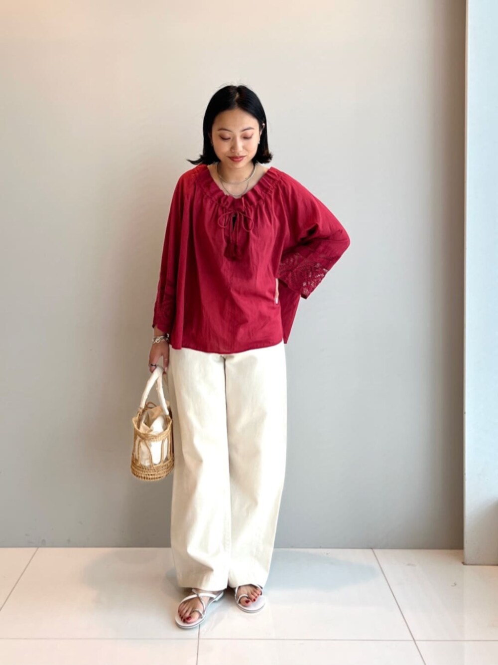 ホワイト系のトートバッグ、レッド系のシャツ/ブラウス、ホワイト系のデニムパンツを着用したレディースの夏コーディネートの1枚目の写真