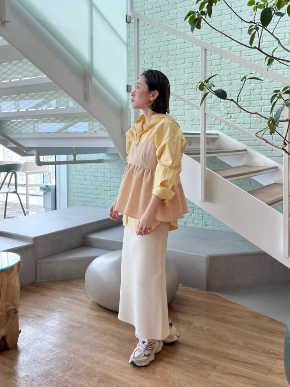 イエロー系のシャツ/ブラウス、イエロー系のタンクトップ、ホワイト系のスカートを着用したレディースの春コーディネートの1枚目の写真