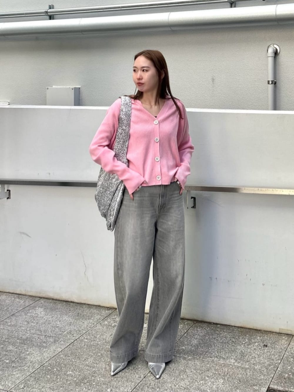 ピンク系のカーディガン/ボレロ、グレー系のデニムパンツを着用したレディースの冬コーディネートの1枚目の写真