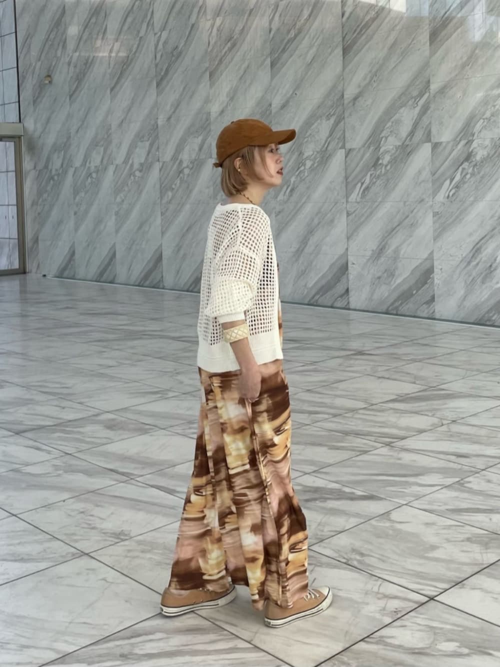 イエロー系のワンピース、ホワイト系のカーディガン/ボレロを着用したレディースの春コーディネートの1枚目の写真