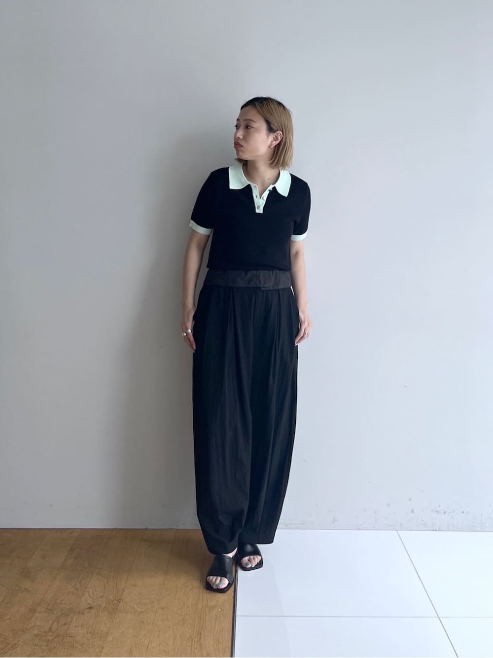 ブラック系のニット/セーター、ブラック系のその他パンツ、ブラック系のサンダルを着用したレディースの春コーディネートの1枚目の写真