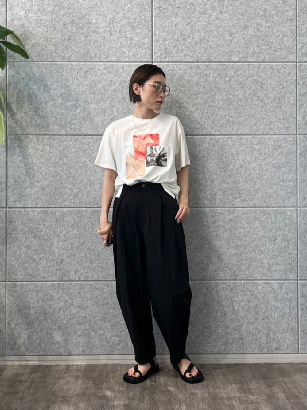 ブラック系のサンダル、ブラック系のその他パンツ、ホワイト系のTシャツ/カットソーを着用したレディースの夏コーディネートの1枚目の写真