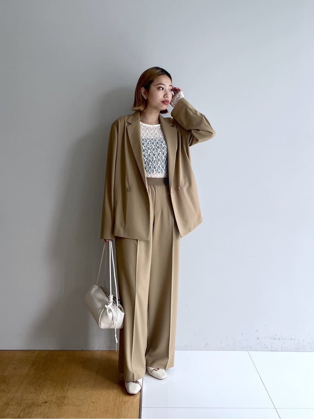 イエロー系のテーラードジャケット、ホワイト系のTシャツ/カットソー、イエロー系のその他パンツを着用したレディースの春コーディネートの1枚目の写真