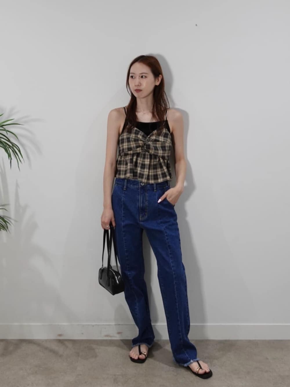 ブルー系のデニムパンツ、ベージュ系のタンクトップを着用したレディースの夏コーディネートの1枚目の写真