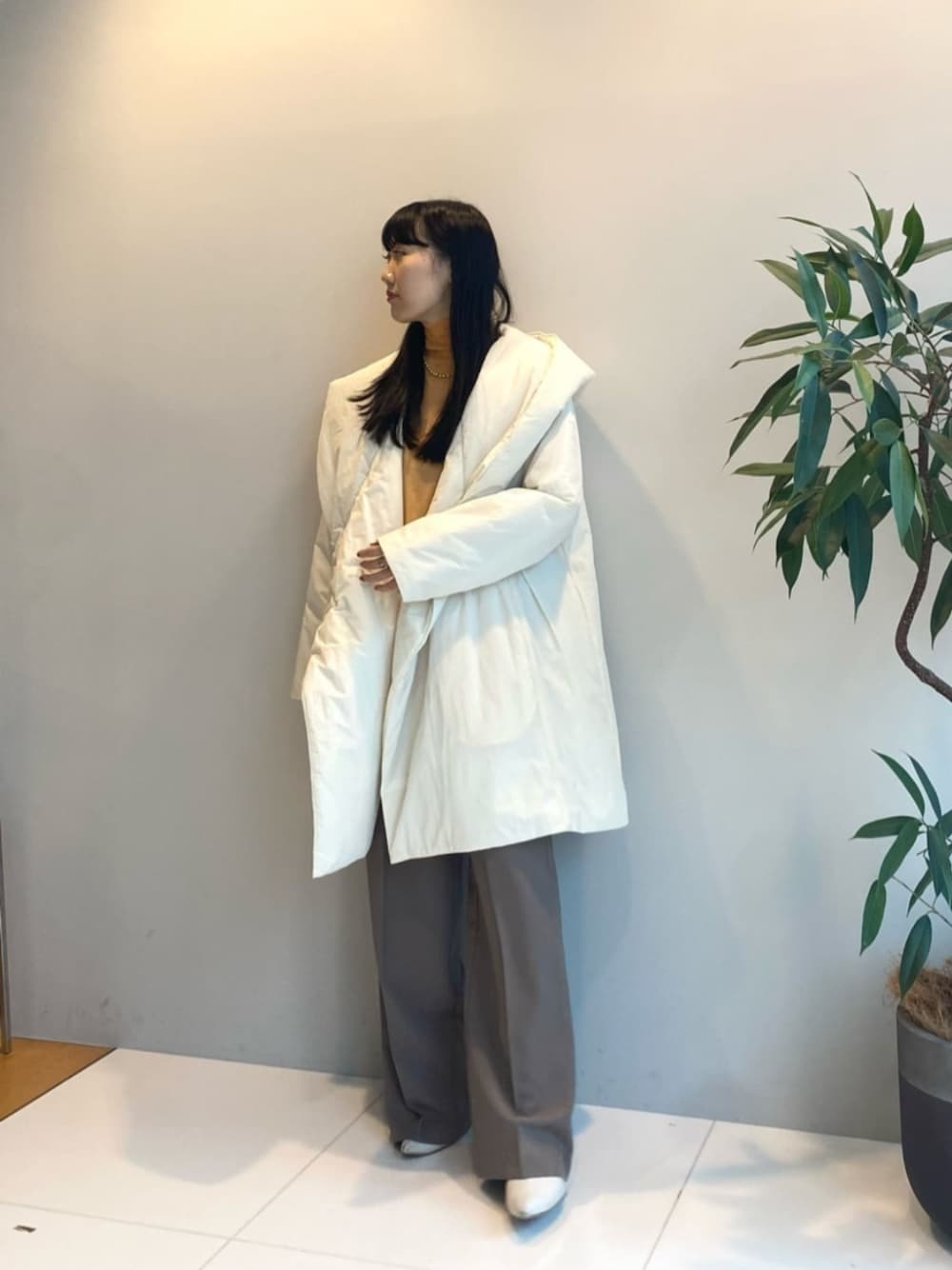 ブラウン系のその他パンツ、ホワイト系のその他アウター、オレンジ系のニット/セーターを着用したレディースの秋コーディネートの1枚目の写真