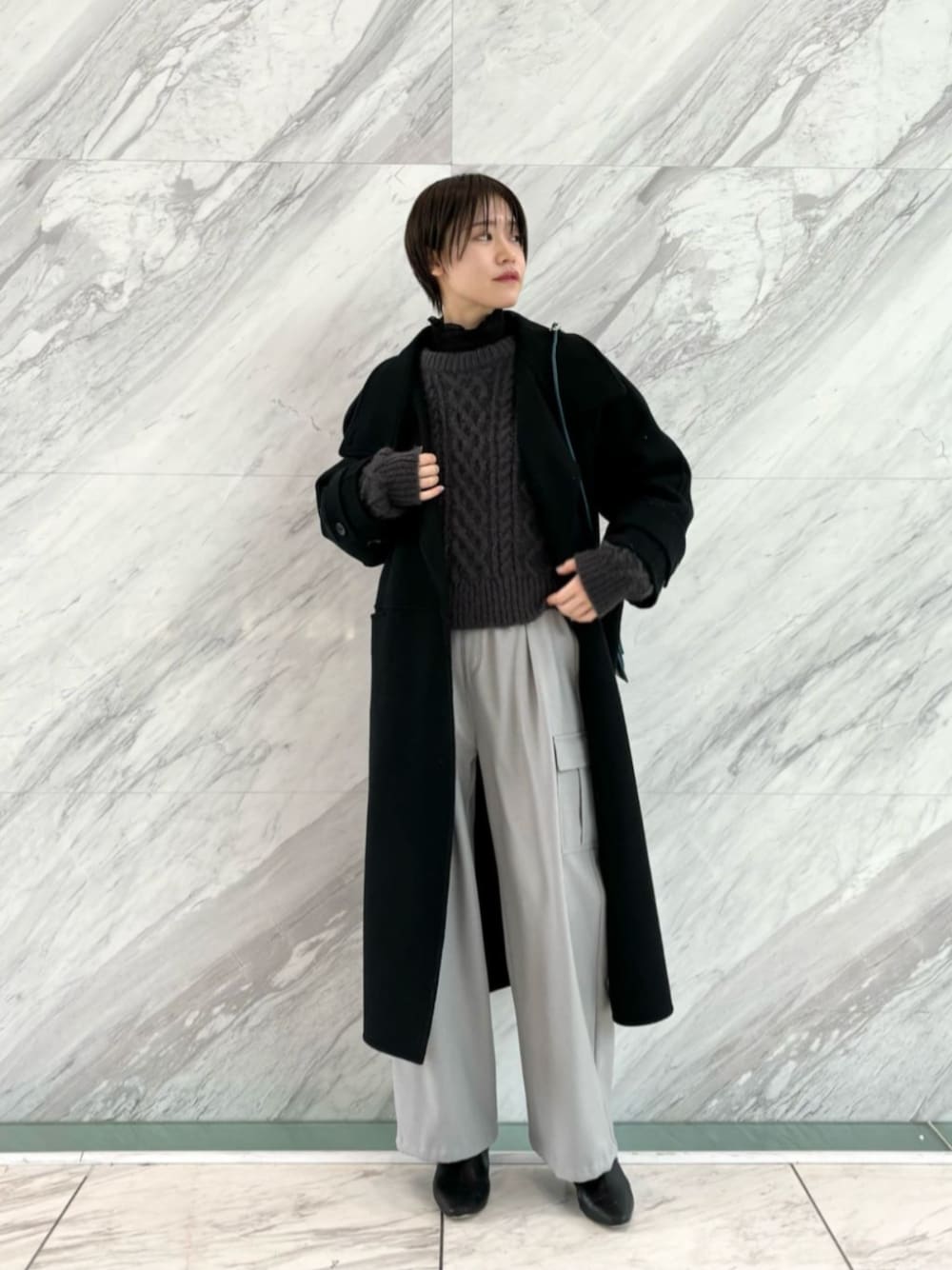 グレー系のその他パンツ、ブラック系のその他アウター、グレー系のニット/セーターを着用したレディースの冬コーディネートの1枚目の写真