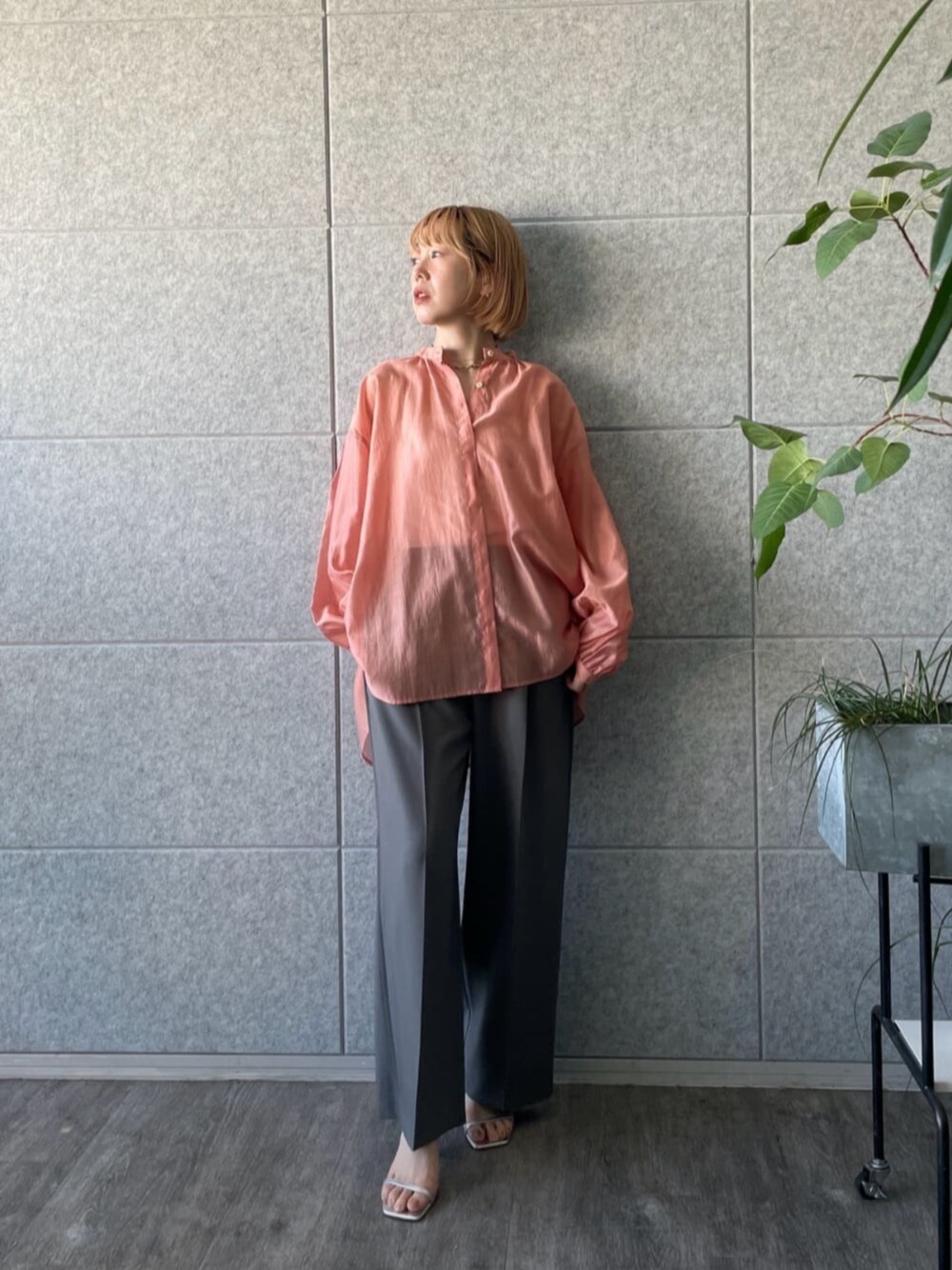 グレー系のその他パンツ、オレンジ系のシャツ/ブラウスを着用したレディースの春コーディネートの1枚目の写真