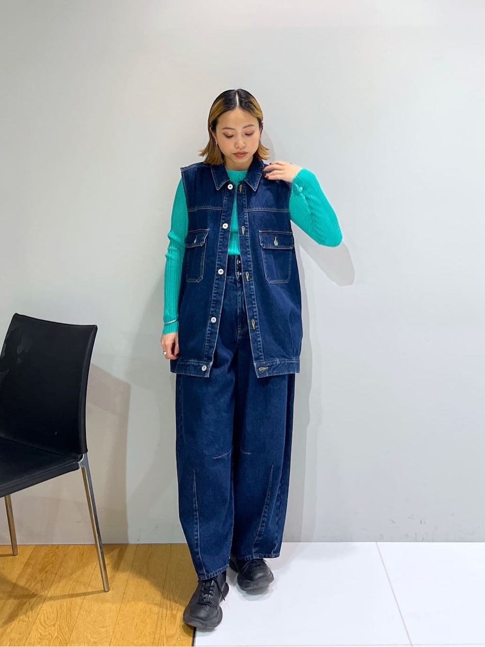 ブルー系のデニムジャケット、グリーン系のニット/セーター、ブルー系のデニムパンツを着用したレディースの冬コーディネートの1枚目の写真