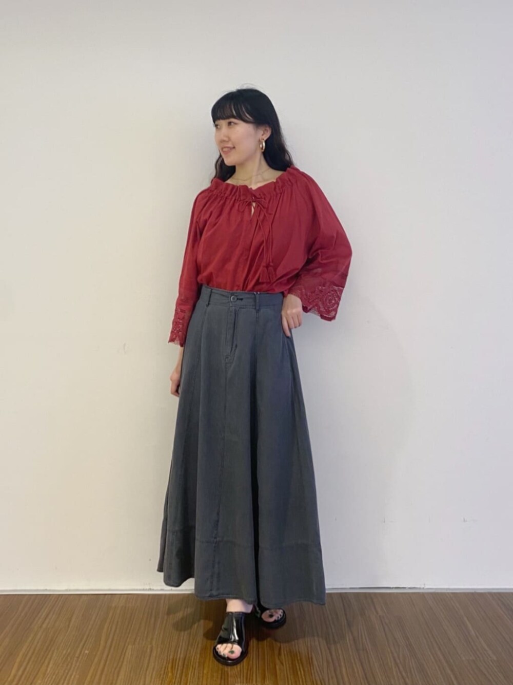 ブラック系のサンダル、グレー系のスカート、レッド系のシャツ/ブラウスを着用したレディースの夏コーディネートの1枚目の写真