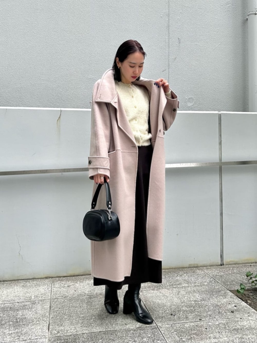 ブラック系のショルダーバッグ、ブラウン系のスカート、グレー系のその他アウターを着用したレディースの冬コーディネートの1枚目の写真