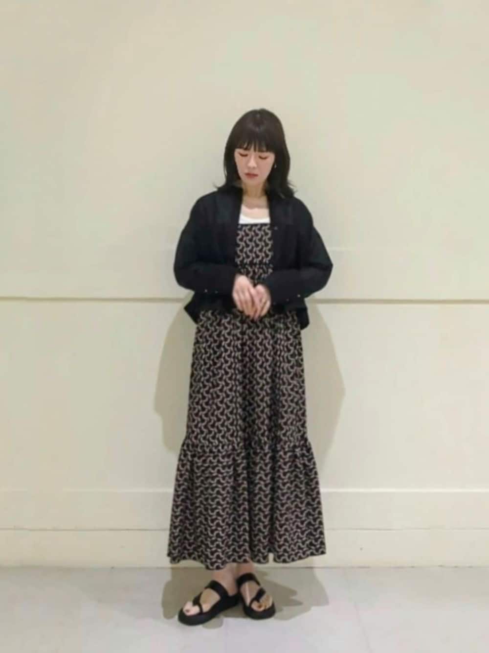 ブラック系のワンピース、ブラック系のシャツ/ブラウスを着用したレディースの春コーディネートの1枚目の写真