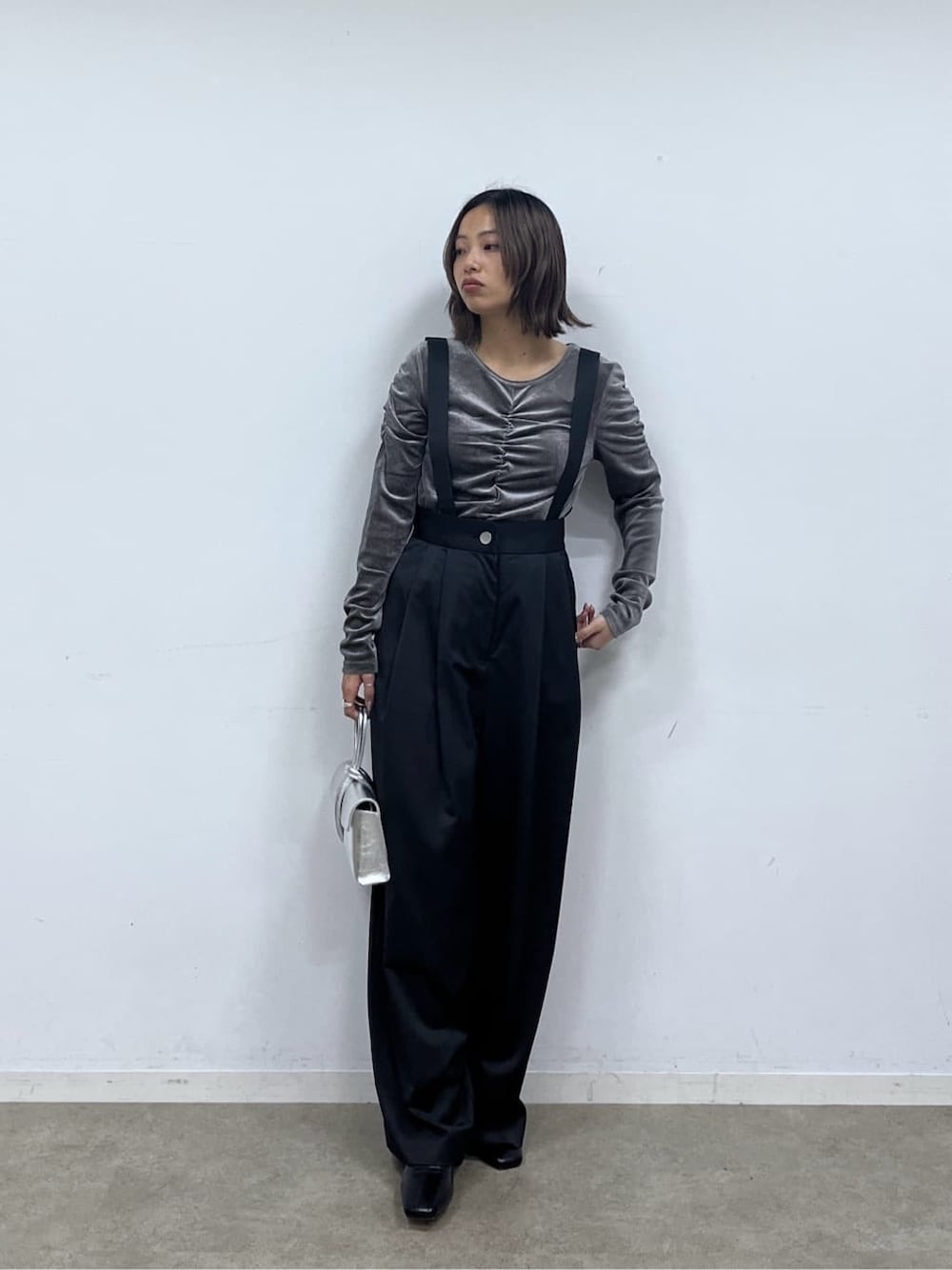 ブラック系のサロペット/オーバーオール、グレー系のTシャツ/カットソー、シルバー系のハンドバッグを着用したレディースの秋コーディネートの1枚目の写真