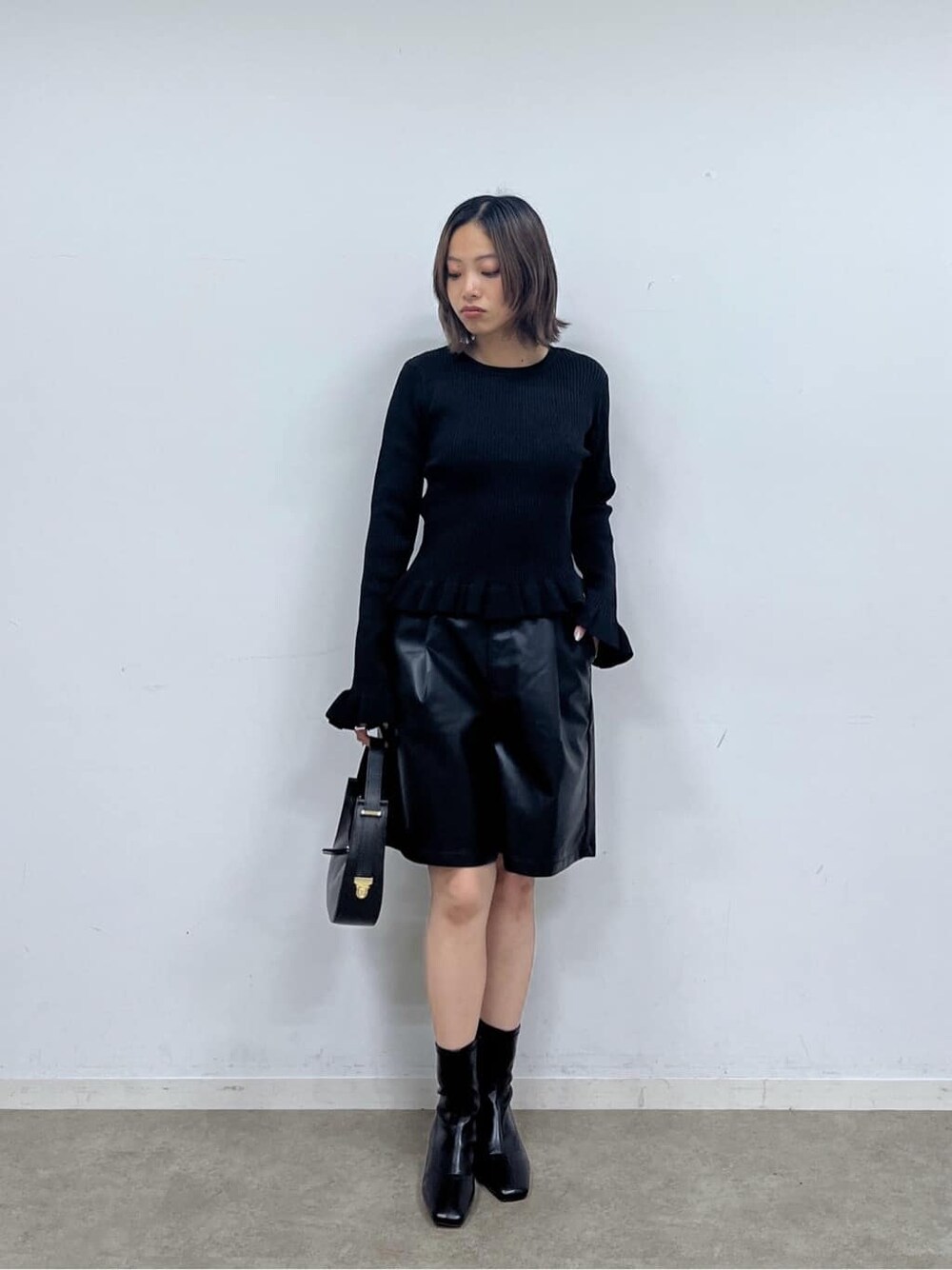 ブラック系のニット/セーター、ブラック系のその他パンツ、ブラック系のハンドバッグを着用したレディースの秋コーディネートの1枚目の写真