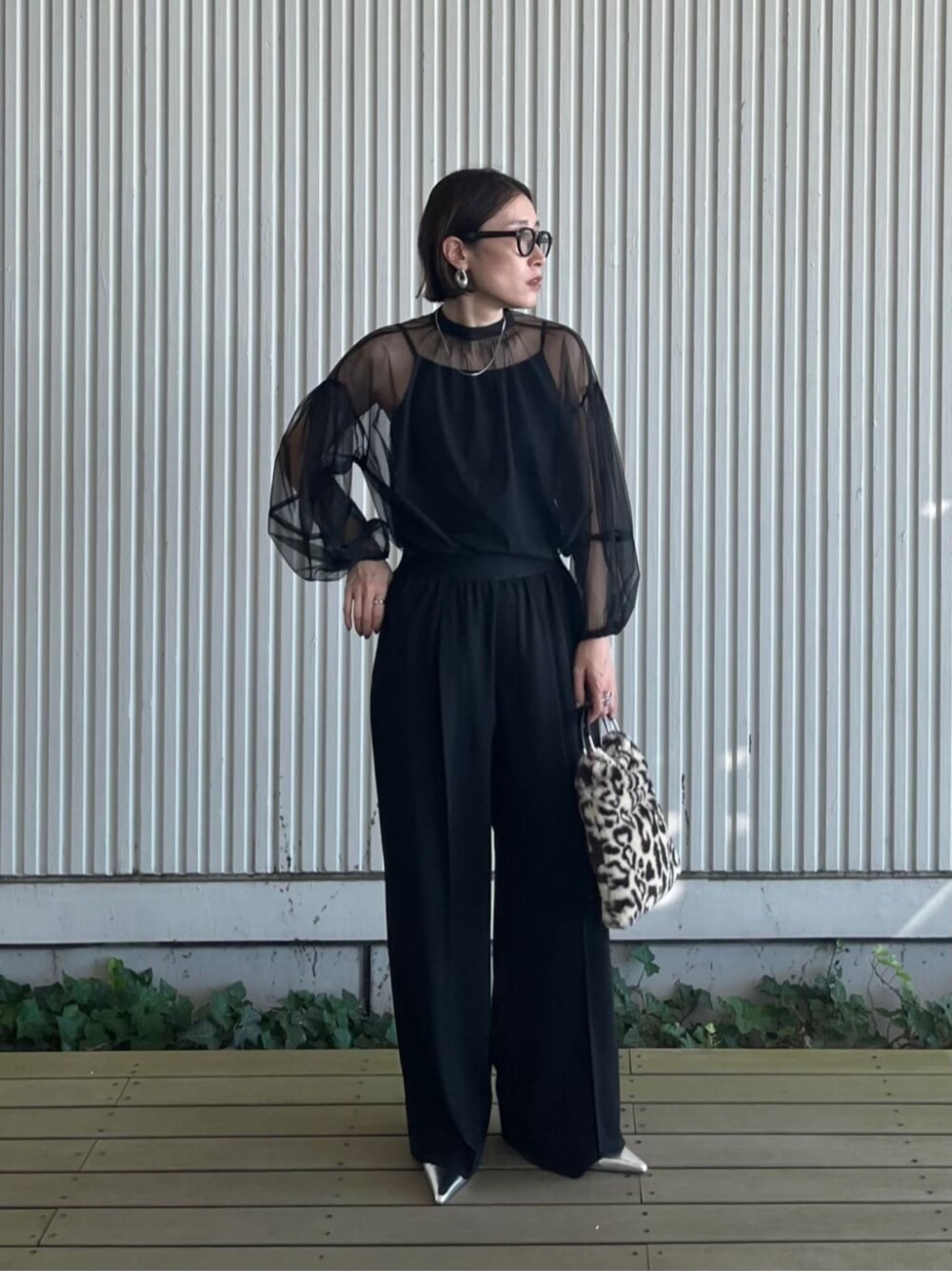 ブラック系のシャツ/ブラウス、ブラック系のその他パンツ、ブラウン系のハンドバッグを着用したレディースの秋コーディネートの1枚目の写真