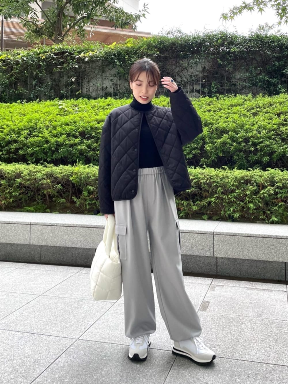 ホワイト系のトートバッグ、ブラック系のノーカラーコート、ブラック系のニット/セーターを着用したレディースの冬コーディネートの1枚目の写真