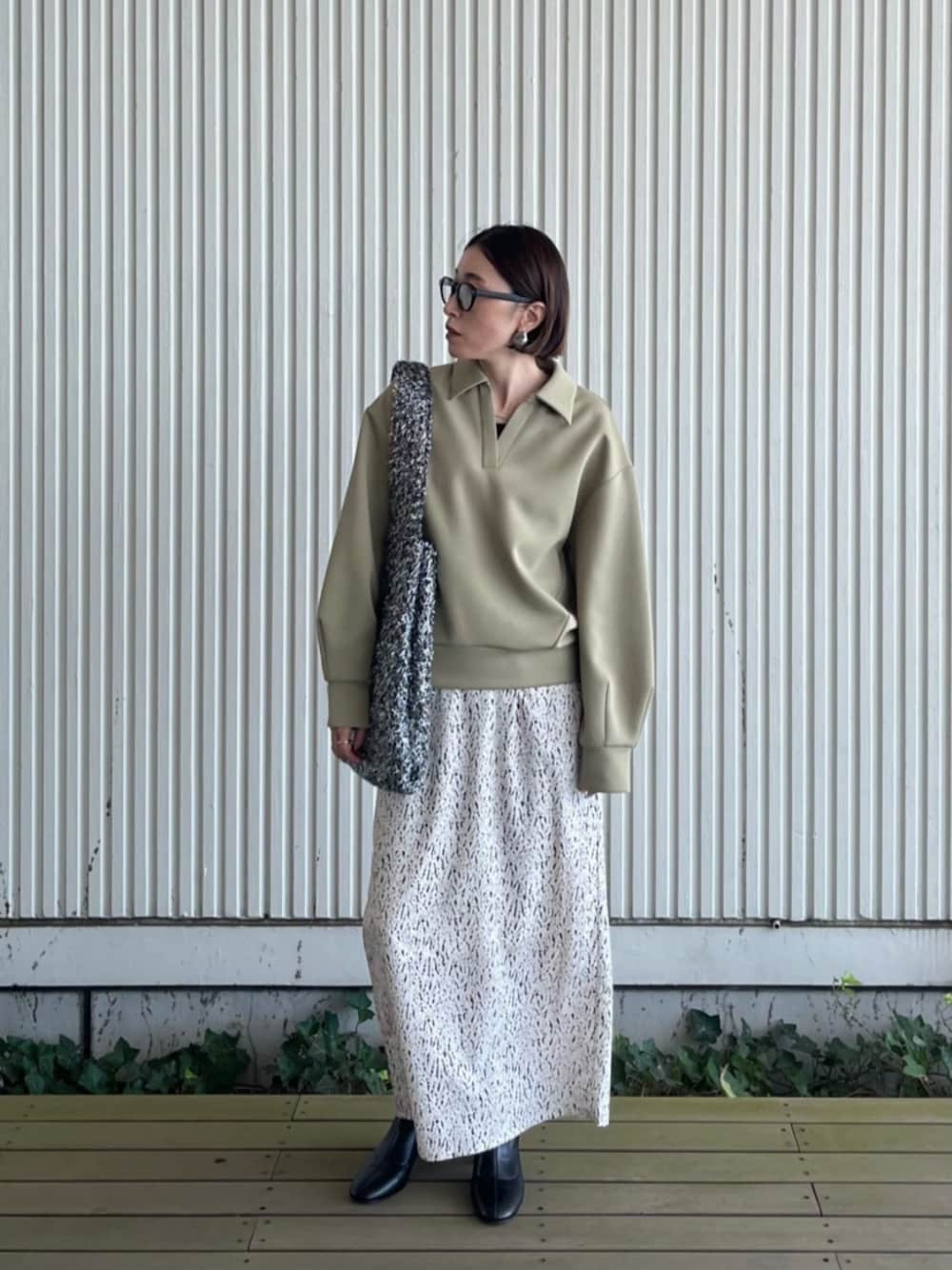 ホワイト系のスカート、シルバー系のトートバッグ、グリーン系のTシャツ/カットソーを着用したレディースの秋コーディネートの1枚目の写真