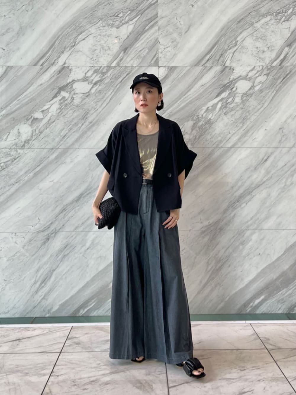 ブラック系のテーラードジャケット、グレー系のその他パンツ、ゴールド系のタンクトップを着用したレディースの夏コーディネートの1枚目の写真