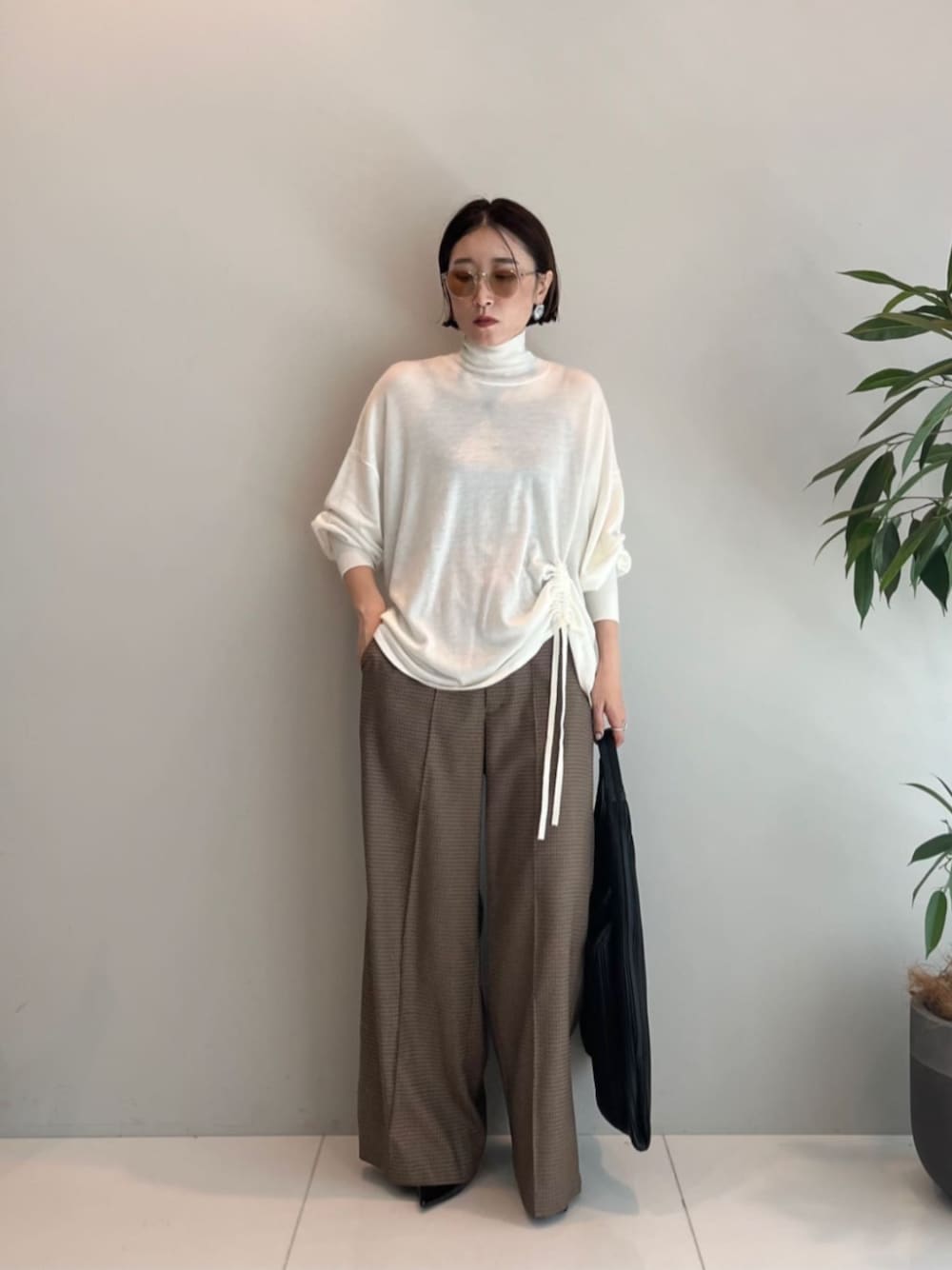 ホワイト系のニット/セーター、ベージュ系のその他パンツ、ブラック系のトートバッグを着用したレディースの秋コーディネートの1枚目の写真