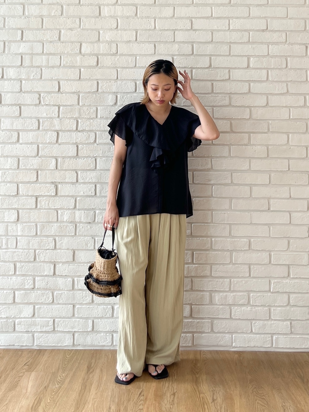 ブラック系のシャツ/ブラウス、グリーン系のその他パンツ、ベージュ系のハンドバッグを着用したレディースの夏コーディネートの1枚目の写真