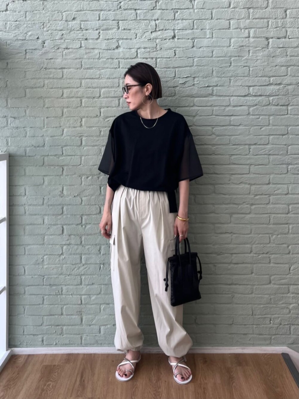 グレー系のその他パンツ、ブラック系のTシャツ/カットソーを着用したレディースの夏コーディネートの1枚目の写真