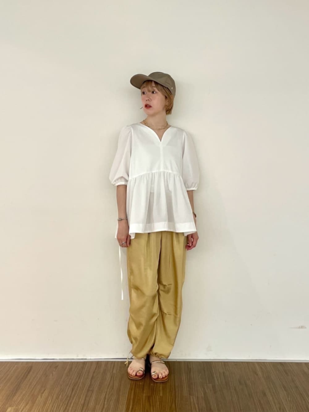 ベージュ系のその他パンツ、ホワイト系のTシャツ/カットソー、グリーン系のキャップを着用したレディースの夏コーディネートの1枚目の写真