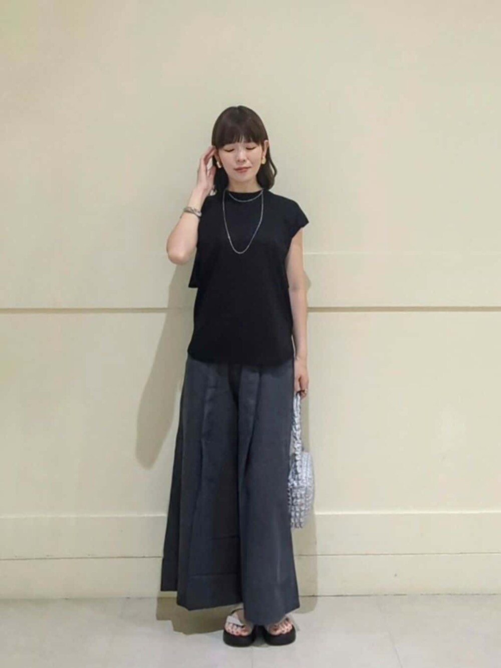 ホワイト系のサンダル、グレー系のその他パンツ、ブラック系のTシャツ/カットソーを着用したレディースの夏コーディネートの1枚目の写真