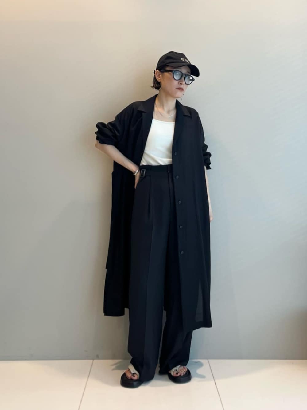 ホワイト系のサンダル、ブラック系のその他パンツ、ブラック系のシャツ/ブラウスを着用したレディースの夏コーディネートの1枚目の写真